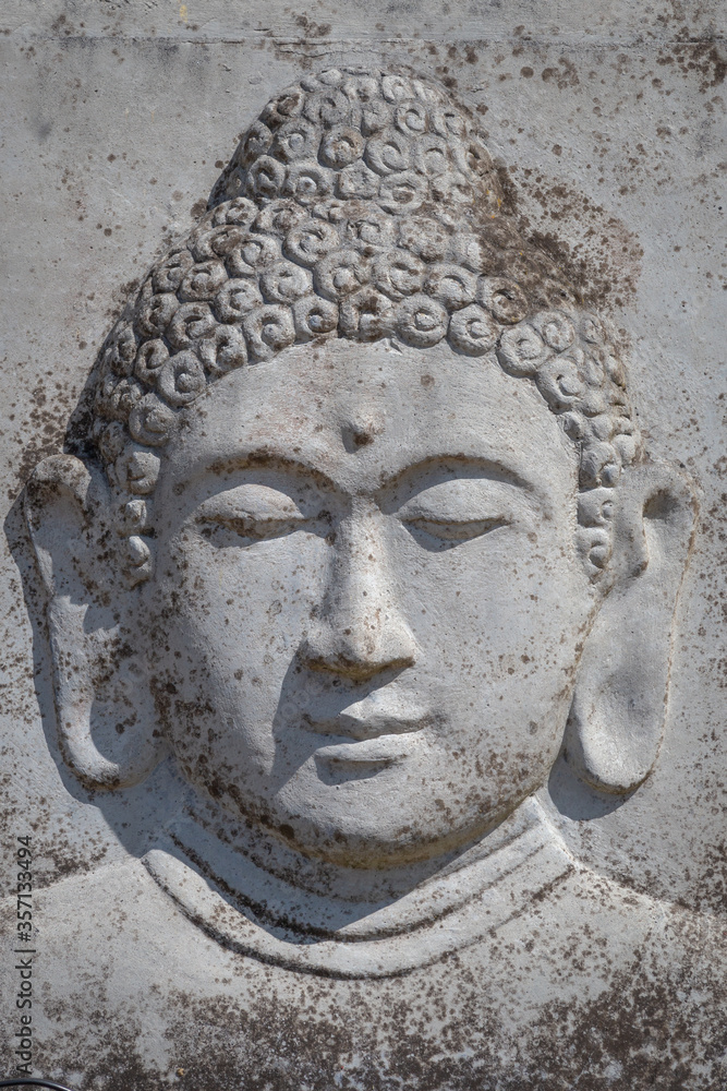 Weathered stone with buddha as garden ornament