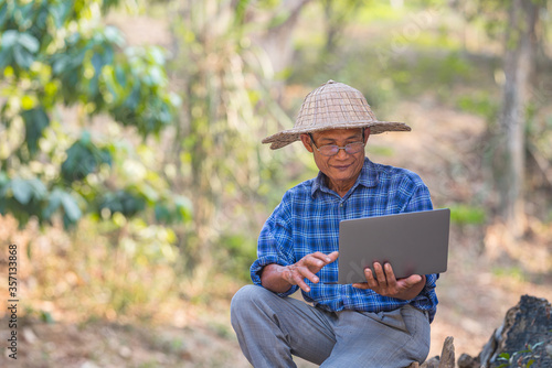 Farmer Asian with smartphone and laptop,Business and technology concept