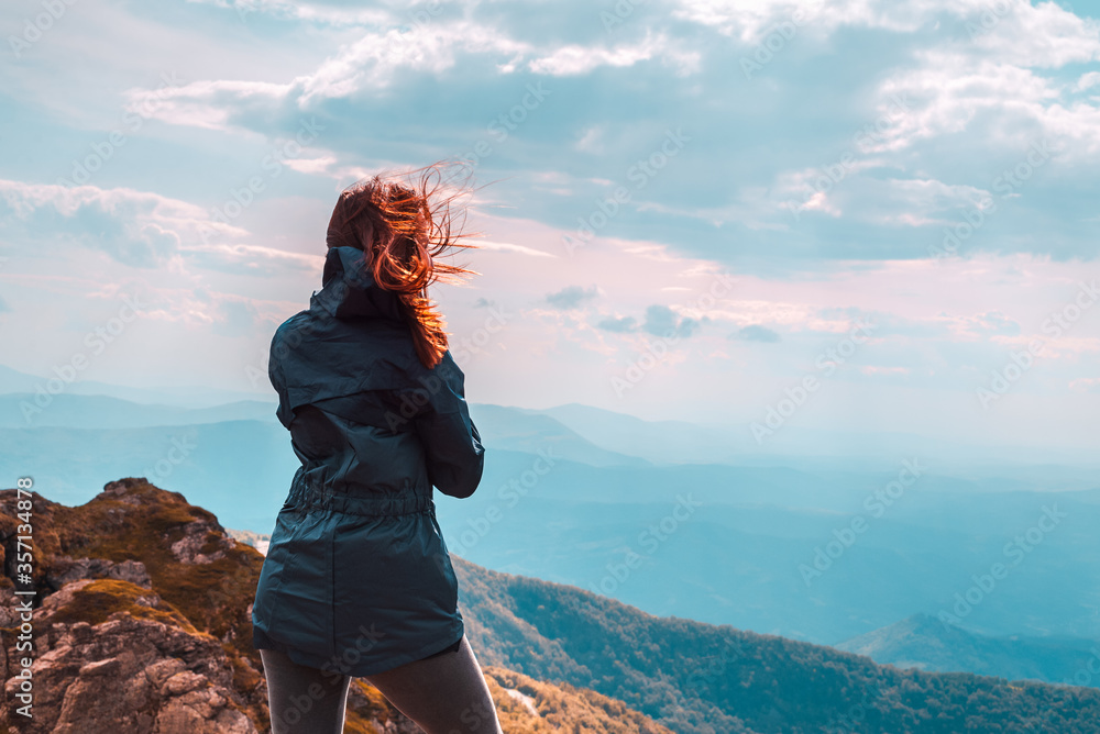 Woman hiker on top of the mountain looking to view Woman hiker on top of the mountain looking to view
