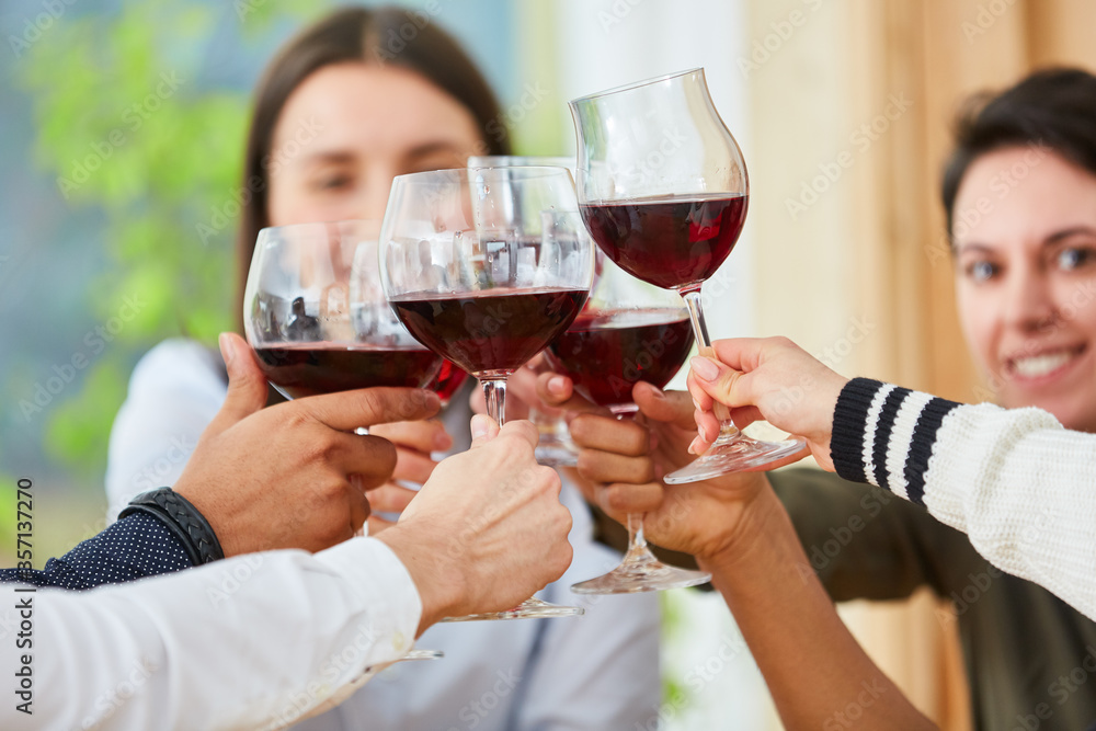 Gruppe Freunde beim Anstoßen mit Glas Rotwein