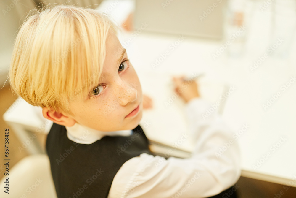 Boy as a student in the classroom while learning Boy as a student in the classroom while learning