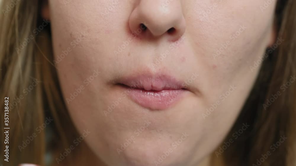 Close-up face and lips. Overweight girl bites off potato chips and drinks cola from a straw Close-up face and lips. Overweight girl bites off potato chips and drinks cola from a straw