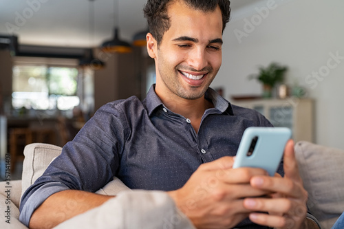 Latin man using smartphone at home