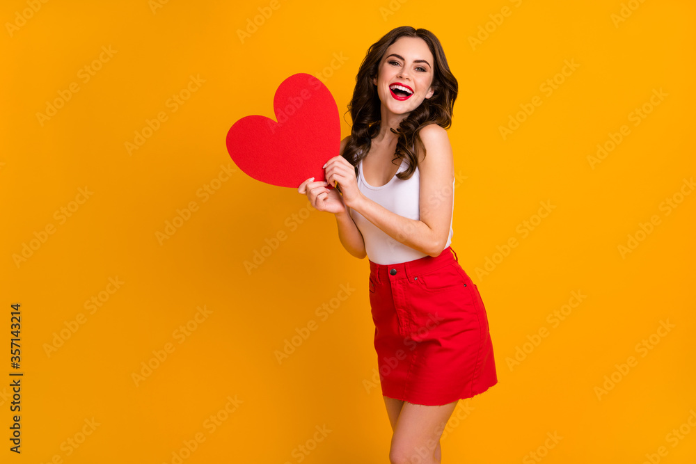 Photo of pretty funny cheerful lady hold big paper heart postcard good mood 14 february present wear white casual tank-top red mini skirt isolated yellow color background Photo of pretty funny cheerful lady hold big paper heart postcard good mood 14 february present wear white casual tank-top red mini skirt isolated yellow color background