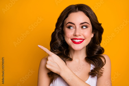 Closeup photo of pretty lady direct finger side empty space show banner advertise demonstrate sale shopping announce wear white casual singlet isolated bright yellow color background