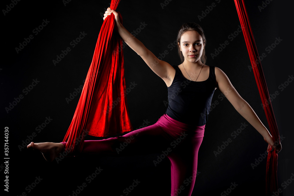 Portrait of purposeful pretty teenage girl with aerial red ribbons on ...