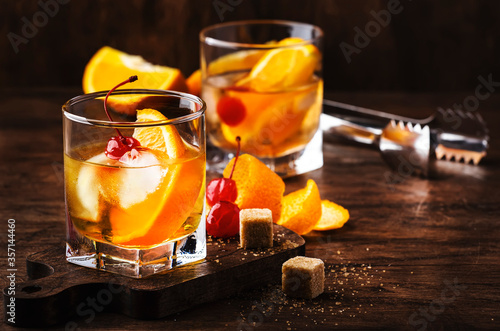 Obraz na plátně Old fashioned cocktail with bourbon, cane sugar, orange slice, cherry and orange