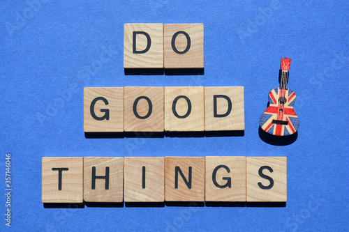 Do Good Things, words in 3D wooden alphabet letters with a ukulele pin, isolated on blue background photo