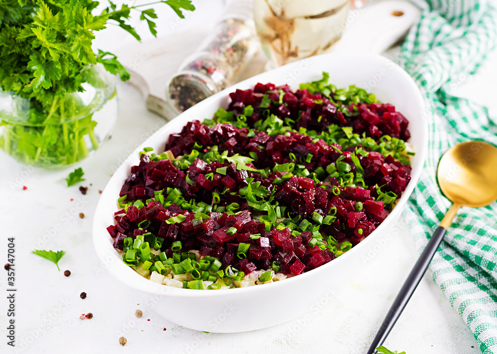 Kosher food, jewish salad. Herring, pickled cucumber, beet, potato and apples salad on white bowl. Kosher food, jewish salad. Herring, pickled cucumber, beet, potato and apples salad on white bowl.