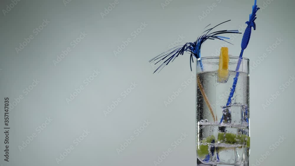 Cooling summer drink with lemon and kiwi rotate on a white background. Transparent fizzy lemonade. Fresh citrus cocktail, healthy drink concept. Cooling summer drink with lemon and kiwi rotate on a white background. Transparent fizzy lemonade. Fresh citrus cocktail, healthy drink concept.