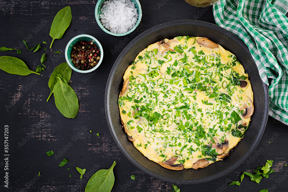 Spinach and mushroom omelette. Frittata made of eggs, mushrooms and spinach. Italian cuisine. Top view, flat lay, copy space Spinach and mushroom omelette. Frittata made of eggs, mushrooms and spinach. Italian cuisine. Top view, flat lay, copy space