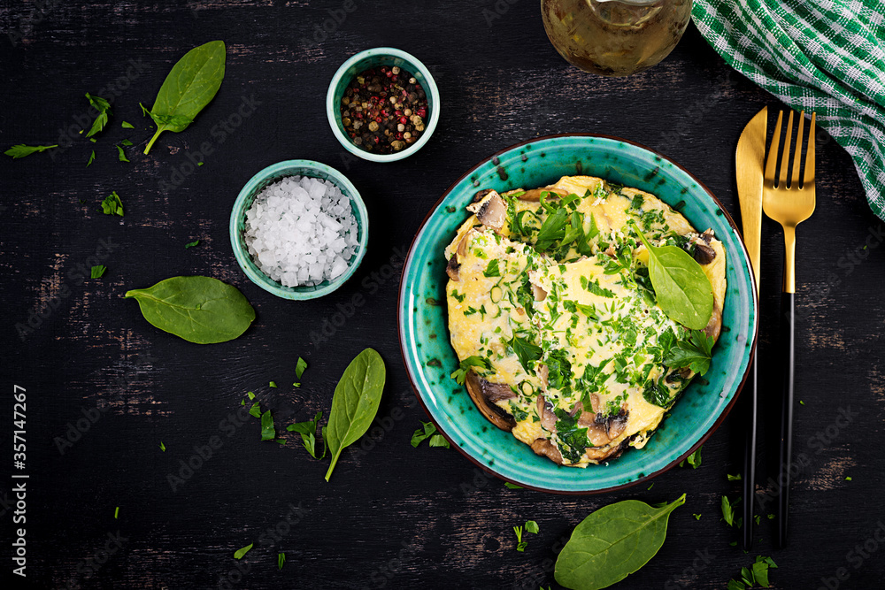 Spinach and mushroom omelette. Frittata made of eggs, mushrooms and spinach. Italian cuisine. Top view, flat lay, copy space Spinach and mushroom omelette. Frittata made of eggs, mushrooms and spinach. Italian cuisine. Top view, flat lay, copy space