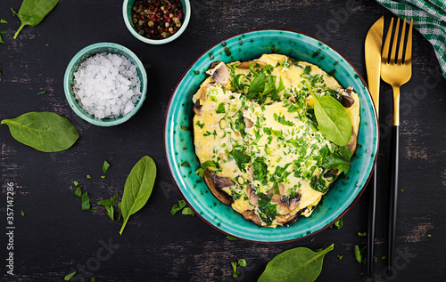 Spinach and mushroom omelette. Frittata made of eggs, mushrooms and spinach. Italian cuisine. Top view, flat lay, copy space