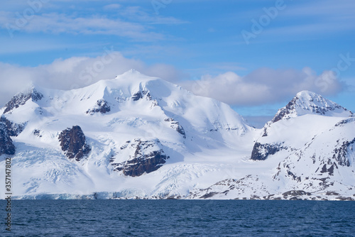 Snow covered mountain with glaciers ending in the ocean on an island called "Prinz Karl Vorland" located on Spitsbergen