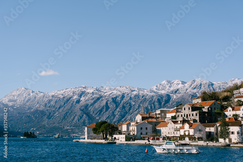 The city of Perast against the backdrop of snow-capped mountains.