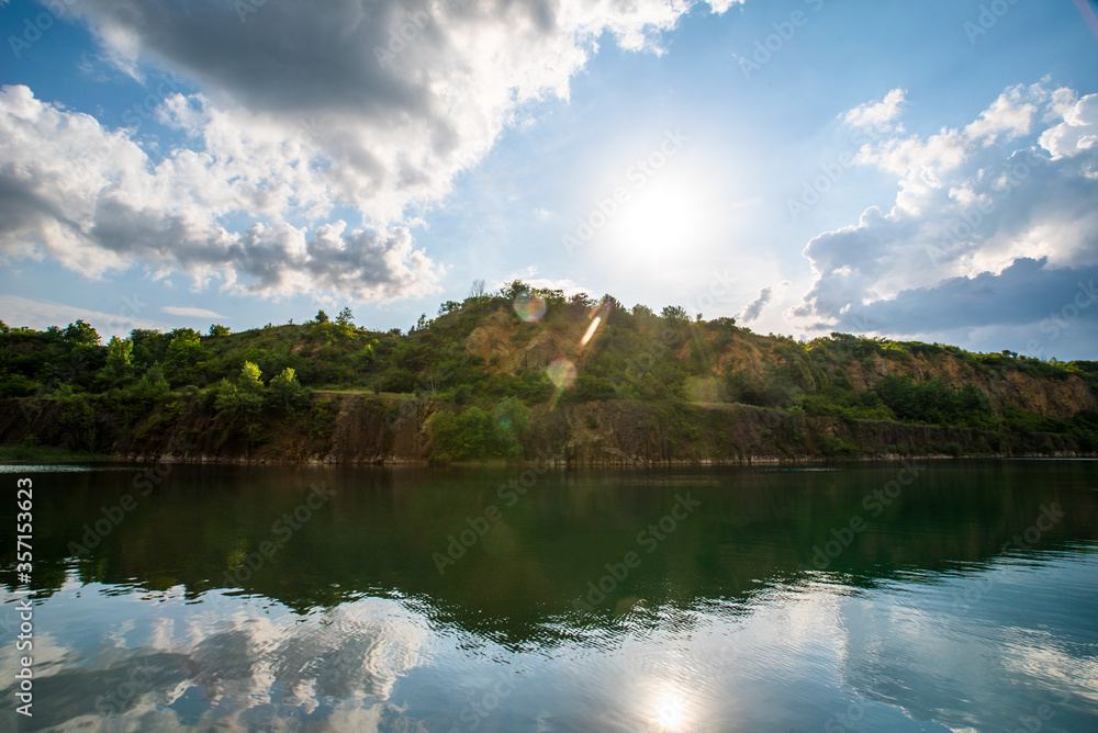 Stone quarry with lake. Stone mining in the canyon. quarry background of trees and sun.