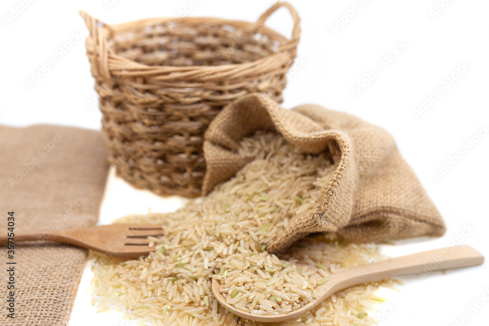 Raw brown rice in brown sack, healthy food background.
