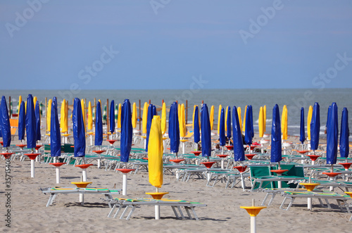 closed umbrellas on the beach without people due to the economic
