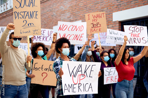 Foto Crowd of protestors rallying on city streets against coronavirus measures