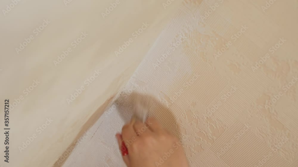 Brush in hand paints white beige ribbed wallpaper Brush in hand paints white beige ribbed wallpaper