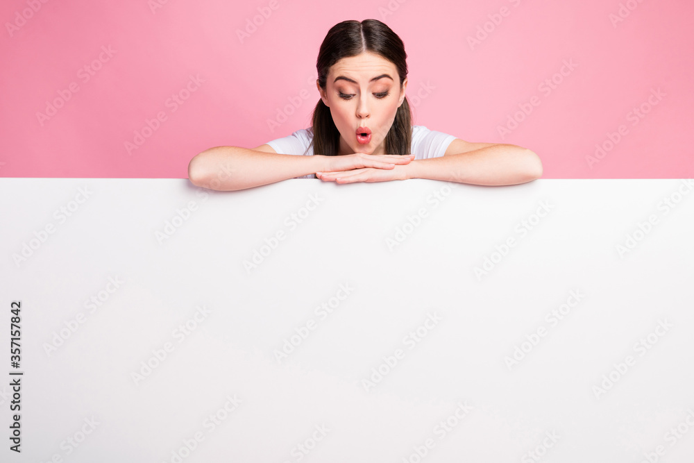 Portrait of nice attractive lovely charming amazed cheerful cheery girl looking at copy empty blank space bill board presentation isolated over pink pastel color background