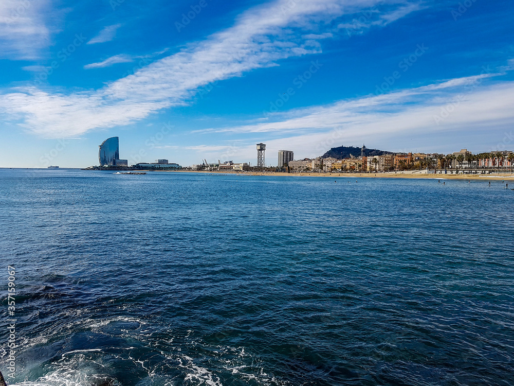 Barcelona in barcelonetta beach promenade with palms sea ocean blue water clear sky hotel w building spain tourism