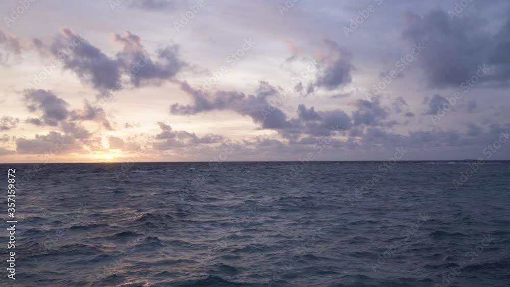 The beautiful sun setting in the horizon of the waves of Maldives - wide The beautiful sun setting in the horizon of the waves of Maldives - wide
