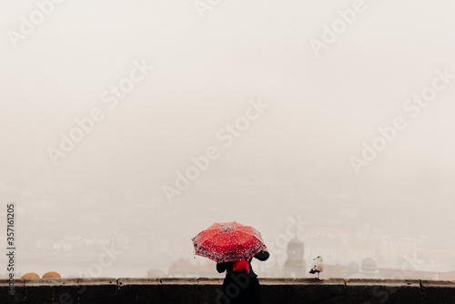 Woman with a red umbrella watching the views