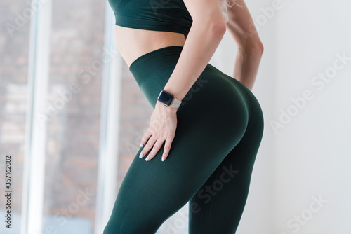 Cropped close up view photo of sexual sporty sportive tempting beautiful attractive nice round ass wearing green tight pants leggings