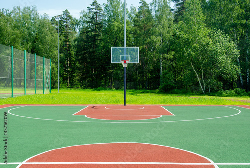 Empty sreet basketball court in the park on the sunny summer day.