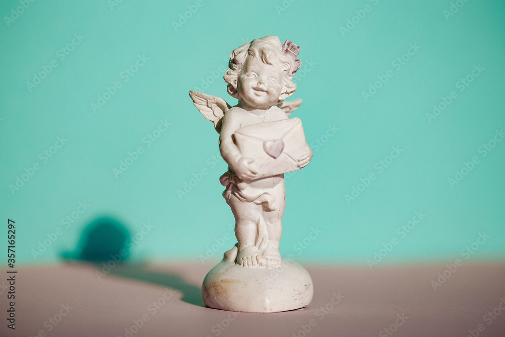 Figurines angels. Decorative angel on a background. Clay Figurines of angels in various poses. Statuette. Figurines angels. Decorative angel on a background. Clay Figurines of angels in various poses. Statuette.