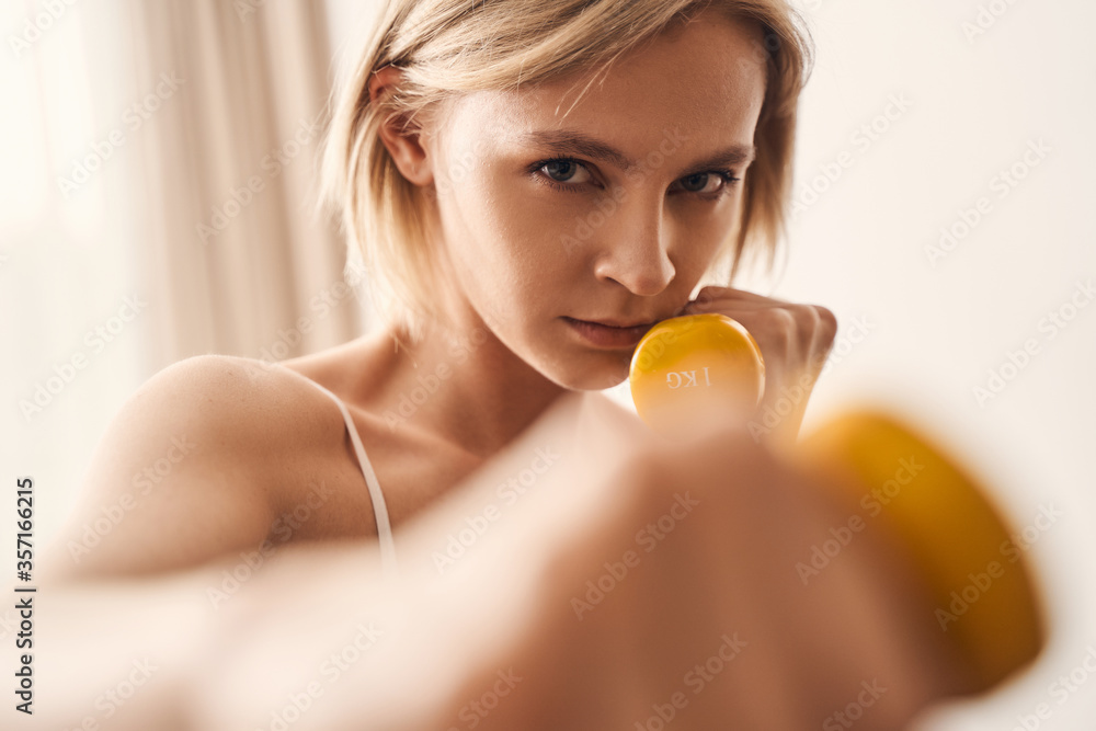 Young Caucasian blonde lady doing strength training Young Caucasian blonde lady doing strength training