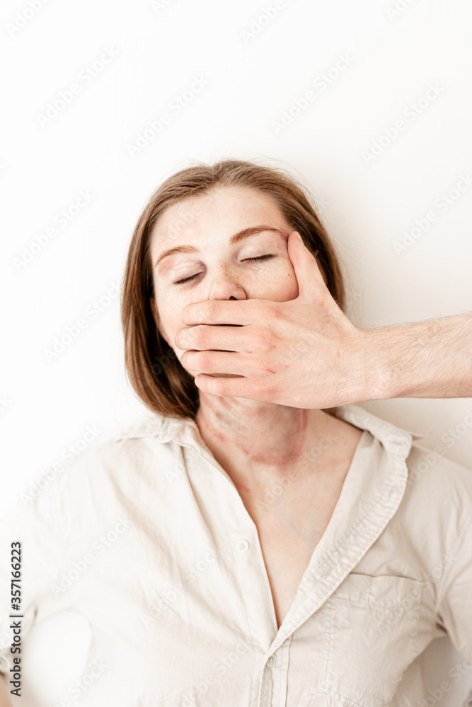 Stressed unhappy frightened female victim in fear with her mouth closed on white background suffering from domestic violence(Concept) Stressed unhappy frightened female victim in fear with her mouth closed on white background suffering from domestic violence(Concept)