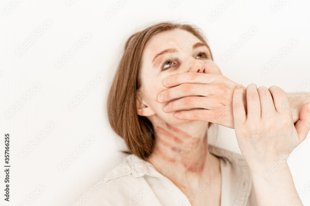 Stressed unhappy frightened female victim in fear with her mouth closed on white background suffering from domestic violence Stressed unhappy frightened female victim in fear with her mouth closed on white background suffering from domestic violence