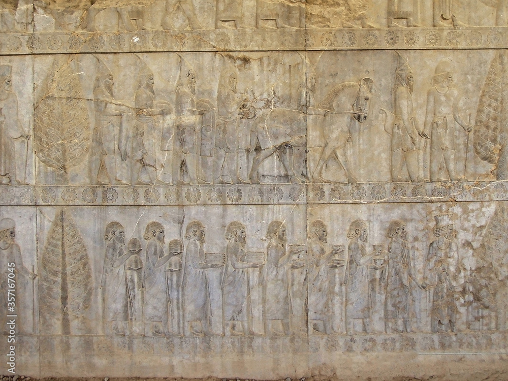Bas-relief on wall of palace Apadana in Persepolis, ex-capital of Ancient Persia (near Shiraz, Iran). Relief is depicting march of King's servants & foreign warriors bringing gifts to their lord