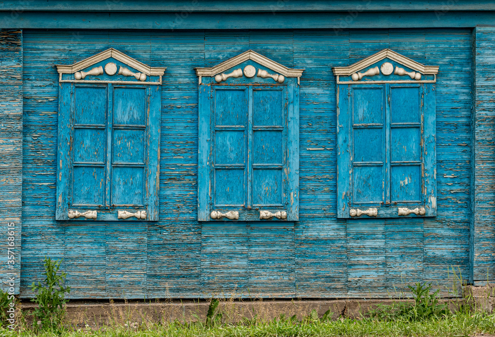 Texture, wall of an old wooden house with shuttered windows, painted blue Texture, wall of an old wooden house with shuttered windows, painted blue