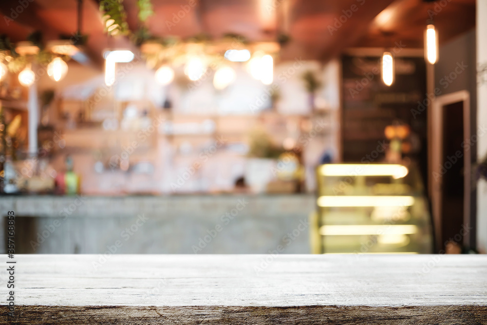 Empty wooden desk space platform and blurred resturant or coffee shop background for product display montage.