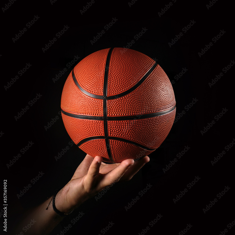 Basketball and hand, black background                        
