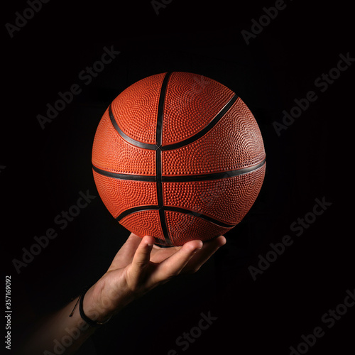 Basketball and hand, black background                          © efks