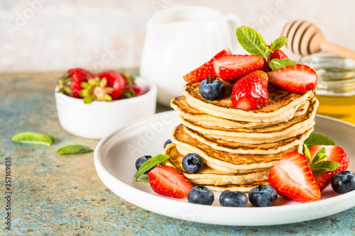 Pancakes with fresh berries and honey.
