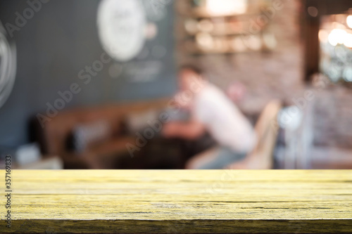 Empty wooden table space platform and blurred restaurant or coffee shop background for product display montage.