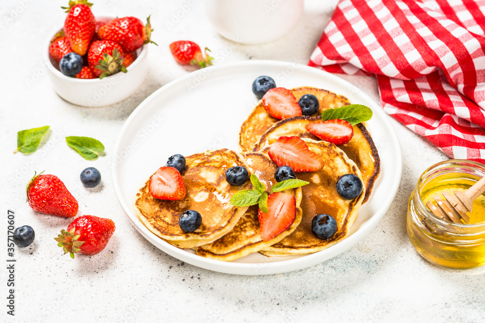 Pancakes with fresh berries and honey.