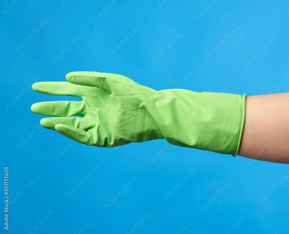 green rubber glove for cleaning dressed on a female hand