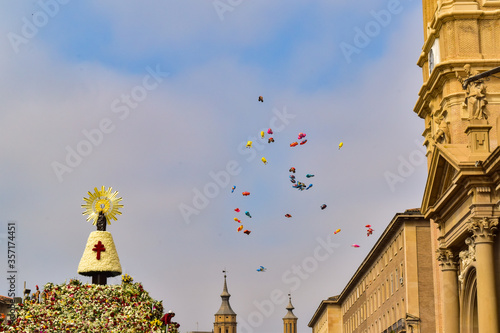 Fototapeta Children's balloons flying free over the Virgen del Pilar full of flowers on the