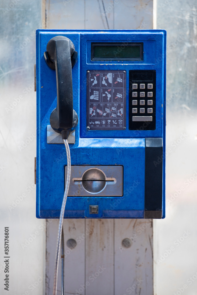 blue public payphone on a city street blue public payphone on a city street