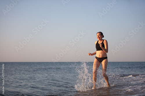An elderly woman runs along the beach. © Светлана Лазаренко