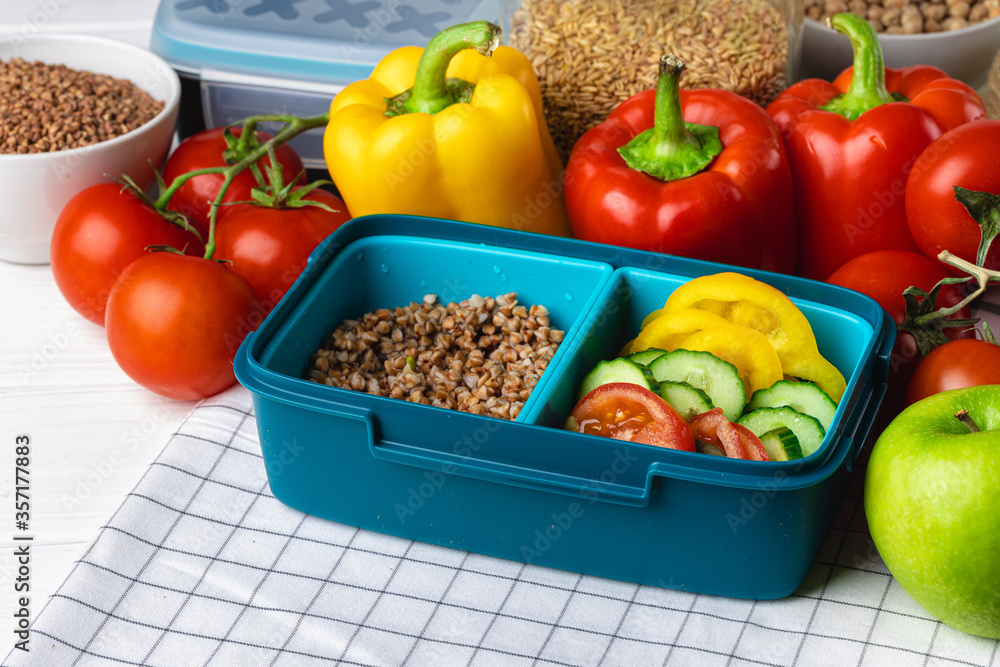 Lunch box with cooked buckwheat and fresh vegetable salad Lunch box with cooked buckwheat and fresh vegetable salad
