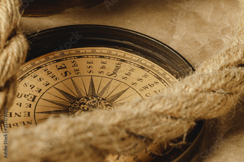 Ship rope and compass on wooden background photo