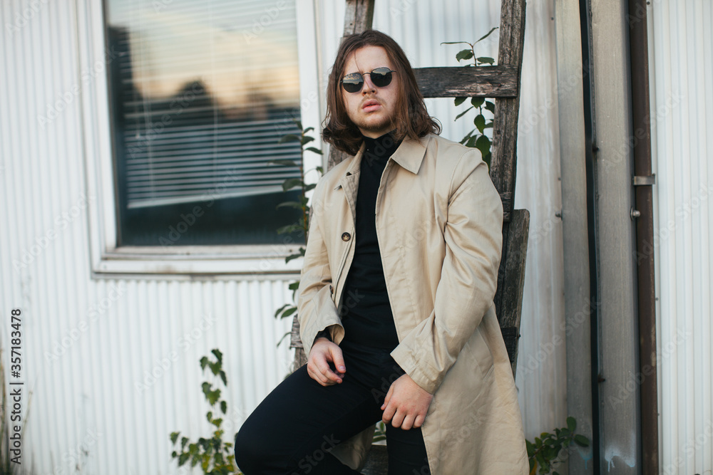 A man in a white coat. A handsome man in a jacket with long hair. Male model with long hair. Fashion of the 90s. A man in a white coat. A handsome man in a jacket with long hair. Male model with long hair. Fashion of the 90s.
