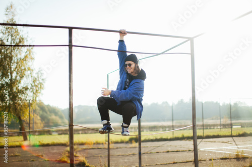 A teenager plays sports. Fashion photos of young men. Fashion of the 90s. A handsome man in a blue jacket.